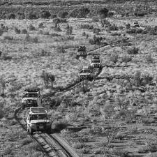 a group of vehicles driving through a field